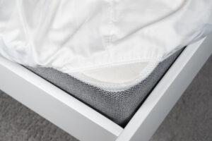 Weißes Satinlaken auf einem elastischen Band auf der Matratze