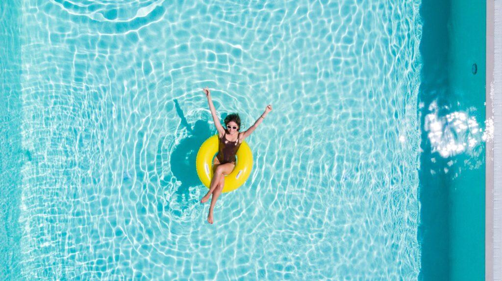 Eine Frau in einem gelben Schwimmreifen im Pool