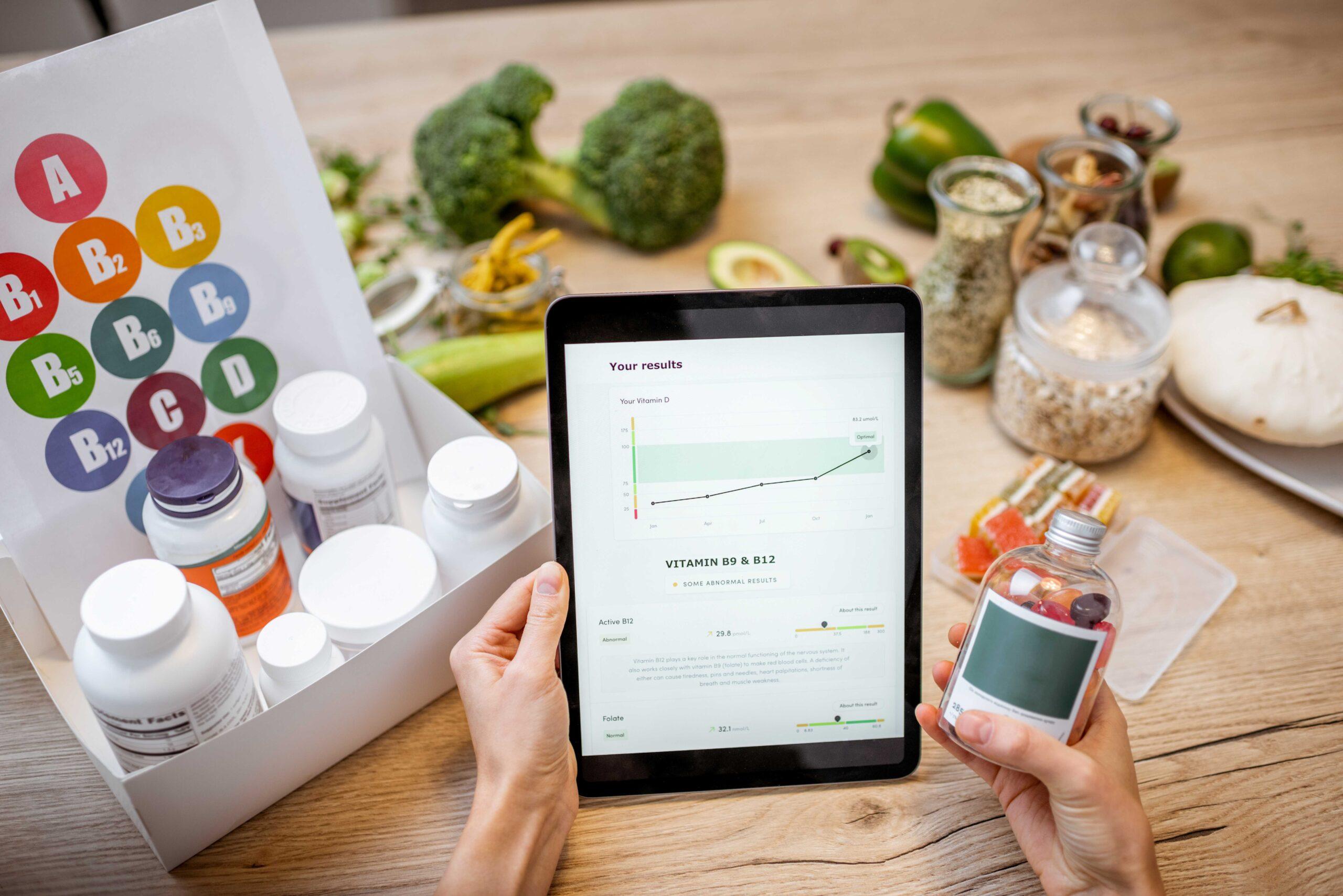 Frau überprüft das Ergebnis medizinischer Tests auf einem digitalen Tablet, Nahaufnahme mit Nahrungsergänzungsmitteln im Hintergrund.